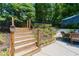 Wooden stairs with rope railing leading to patio, along with a landscaped garden and outdoor seating at 4010 Tamarack Nw Dr, Kennesaw, GA 30152