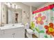 Bright bathroom featuring a colorful flower shower curtain, sink and vanity at 4010 Tamarack Nw Dr, Kennesaw, GA 30152