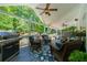 View of the covered deck with an outdoor kitchen, seating, and ceiling fans overlooking the backyard at 4010 Tamarack Nw Dr, Kennesaw, GA 30152