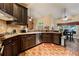 Modern kitchen with dark cabinets, stainless appliances, and brick floors at 4010 Tamarack Nw Dr, Kennesaw, GA 30152