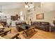 Open-concept living room with hardwood floors, leather couches, and staircase at 4010 Tamarack Nw Dr, Kennesaw, GA 30152
