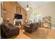 Inviting living room with hardwood floors, stone fireplace, and large window with natural light at 4010 Tamarack Nw Dr, Kennesaw, GA 30152