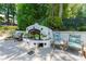 Outdoor fireplace area, perfect for entertaining, with chairs and lush landscaping at 4010 Tamarack Nw Dr, Kennesaw, GA 30152