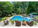 Backyard pool with lounge chairs, lush landscaping, volleyball net, and outdoor pizza oven at 4010 Tamarack Nw Dr, Kennesaw, GA 30152