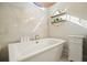 Luxurious bathroom featuring a soaking tub, modern fixtures, and stylish shelving with decor at 720 Tannery Cmn, Alpharetta, GA 30009