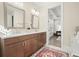 Bathroom vanity with double sinks, wood cabinets, granite countertop, decorative lighting, and a glimpse of a bedroom at 720 Tannery Cmn, Alpharetta, GA 30009