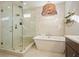 Bathroom featuring a glass enclosed shower, standalone tub, a double vanity, and a decorative hanging light fixture at 720 Tannery Cmn, Alpharetta, GA 30009