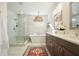 Bathroom featuring a glass enclosed shower, standalone tub, a double vanity, and a decorative hanging light fixture at 720 Tannery Cmn, Alpharetta, GA 30009