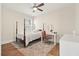 Bedroom with a four-poster bed, desk, and ceiling fan offering a comfortable retreat with a large rug at 720 Tannery Cmn, Alpharetta, GA 30009