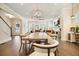Large dining table in a room with a view of the living area and the stairway to the upper level at 720 Tannery Cmn, Alpharetta, GA 30009
