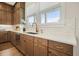 Well-lit kitchen with wood cabinets, quartz countertops, and a modern faucet and sink fixture at 720 Tannery Cmn, Alpharetta, GA 30009