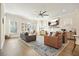 Bright living room with hardwood floors, fireplace, ceiling fan, and modern decor including an office desk at 720 Tannery Cmn, Alpharetta, GA 30009