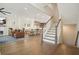Open-concept living room with hardwood floors, fireplace, staircase, and adjacent dining area with natural light at 720 Tannery Cmn, Alpharetta, GA 30009