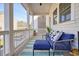 Relaxing covered porch furnished with a comfy blue sofa and an outdoor rug at 720 Tannery Cmn, Alpharetta, GA 30009