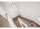 High angle view of a staircase with hardwood steps and white risers, illuminated by an elegant chandelier at 720 Tannery Cmn, Alpharetta, GA 30009