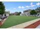 Lush green lawn, outdoor tables, and eateries in a vibrant town square, ideal for community gatherings and relaxation at 720 Tannery Cmn, Alpharetta, GA 30009