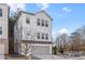 Stylish three-story home with white siding and gray garage door, set against a backdrop of trees at 120 Pinecone Pkwy, Alpharetta, GA 30022