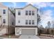 Charming three-story home with white painted brick and siding, a gray garage door, and multiple windows at 120 Pinecone Pkwy, Alpharetta, GA 30022