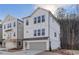Attractive three-story home with white painted brick and siding, a gray garage door, and large windows at 120 Pinecone Pkwy, Alpharetta, GA 30022
