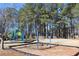 Community playground with swings, slides, and climbing structures, nestled among tall trees for a fun outdoor experience at 2006 Hawthorne Way, Woodstock, GA 30189