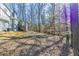 Spacious backyard with gentle slope, trees, and the rear of the house with a wooden staircase at 3585 Ale Cir, Atlanta, GA 30344