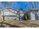 View of the rear of a gray brick and siding home with multi-level construction and a chimney at 3585 Ale Cir, Atlanta, GA 30344