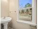 Cozy powder room with a pedestal sink and a backyard view from the window at 4074 Gold Mill Rdg, Canton, GA 30114