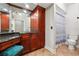 Bathroom featuring granite counters, tile floors, and beautiful wood cabinetry with framed mirror and toilet at 3777 Peachtree Ne Rd # 911, Atlanta, GA 30319