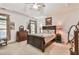 Comfortable bedroom with a tray ceiling, ceiling fan, dark wood furniture and two windows with natural light at 2817 Middlecreek Way # 1703, Cumming, GA 30041