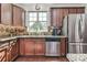 Charming kitchen with stainless steel appliances, dark wood cabinets, and a garden window at 2817 Middlecreek Way # 1703, Cumming, GA 30041