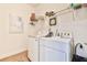 Functional laundry area with washer, dryer, overhead shelving, and tiled flooring at 2817 Middlecreek Way # 1703, Cumming, GA 30041