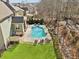 Aerial view of the backyard with a sparkling pool, lush lawn, and mature trees at 2952 Perimeter Cir, Buford, GA 30519