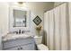 Cozy bathroom with decorative mirror, patterned shower curtain, and updated vanity at 2952 Perimeter Cir, Buford, GA 30519