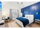 Stylish bedroom with a blue accent wall, desk, and a cozy bed at 2952 Perimeter Cir, Buford, GA 30519