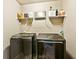 A well-organized laundry room with modern washer and dryer units and storage shelf at 2952 Perimeter Cir, Buford, GA 30519