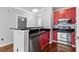 A modern kitchen with stainless steel appliances, red cabinets, and a breakfast bar at 10 Perimeter Summit Ne Blvd # 4312, Atlanta, GA 30319