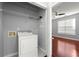 Bright laundry room with washer, wire shelving, and light gray walls adjacent to bedroom at 10 Perimeter Summit Ne Blvd # 4312, Atlanta, GA 30319