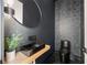Stylish powder room with a black geometric tiled accent wall, modern fixtures, and sleek design at 198 Johnson Ferry Nw Rd, Atlanta, GA 30328