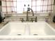 A pristine white sink with a silver faucet set under a window with red plaid curtains at 2870 Whiteview Nw Dr, Acworth, GA 30101