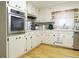 Modern kitchen with stainless steel oven and cooktop, complemented by white cabinets and hardwood floors at 2870 Whiteview Nw Dr, Acworth, GA 30101