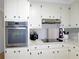 A clean kitchen with stainless steel appliances, light countertops, and dark knobs on the white cabinets at 2870 Whiteview Nw Dr, Acworth, GA 30101
