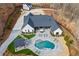 Aerial view of home with pool, stone patio with furniture, green space, long driveway, and garage at 8710 Little Mill Rd, Cumming, GA 30041