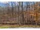 Wooded backyard with a black wooden fence adding charm and privacy to the property at 8710 Little Mill Rd, Cumming, GA 30041