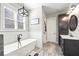 Well-lit bathroom featuring a tub, vanity, and window with natural light at 8710 Little Mill Rd, Cumming, GA 30041