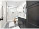 Modern bathroom with a glass shower, patterned tile floor, dark vanity, and white shiplap walls at 8710 Little Mill Rd, Cumming, GA 30041
