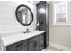 This is a bathroom vanity with shaker cabinets, quartz counters, ship lap accent wall and a round mirror at 8710 Little Mill Rd, Cumming, GA 30041