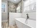 Well-lit bathroom with a walk-in shower and a luxurious tub at 8710 Little Mill Rd, Cumming, GA 30041