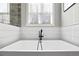 Close up of modern white bathtub with black faucet and window at 8710 Little Mill Rd, Cumming, GA 30041