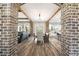 Open-concept layout featuring a dining room with brick accents and views of the kitchen and living room at 8710 Little Mill Rd, Cumming, GA 30041