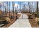 Driveway and black, gated entrance lined with trees and landscaping at 8710 Little Mill Rd, Cumming, GA 30041